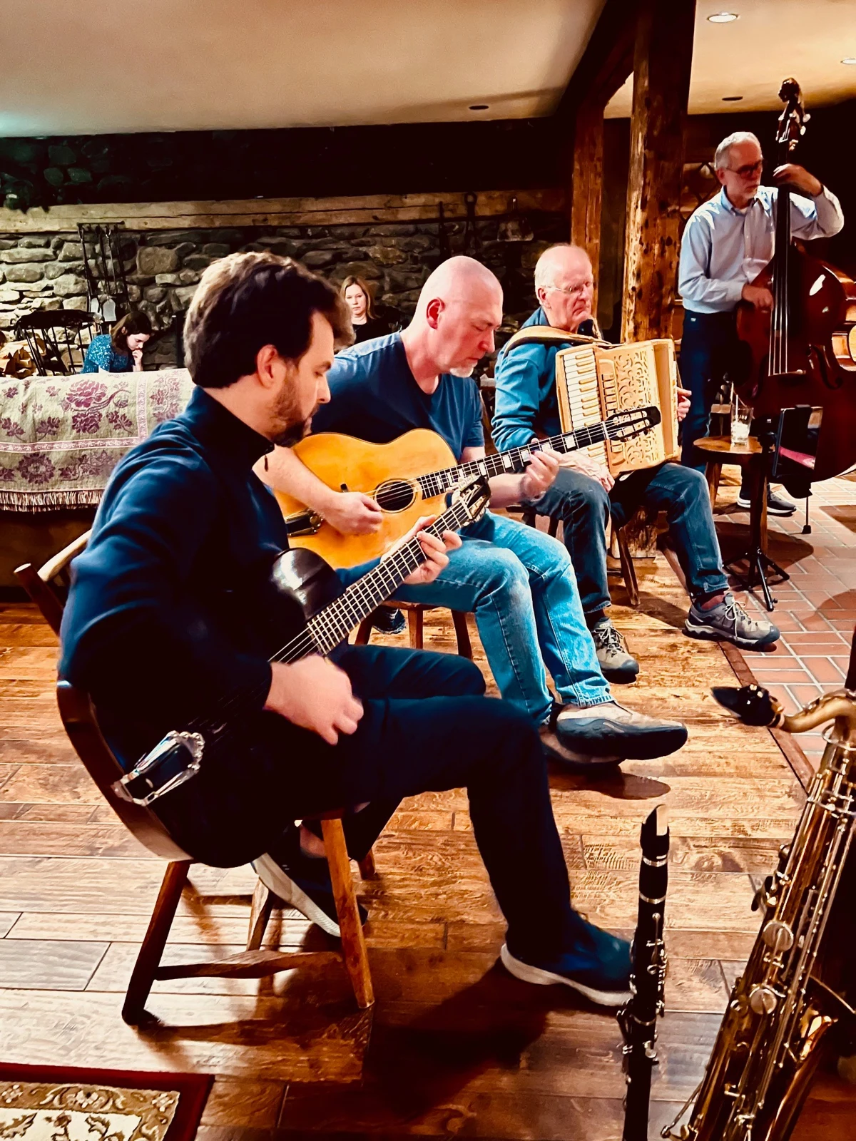 Musicians playing guitars, accordion and upright bass in an informal jam
